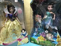 Close-up photo of the Snow White and Tinkerbell dolls displaying detailed costumes and packaging.