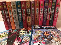 Photo of 12 hardcover Dork Diaries books arranged in a row with visible colorful spines and numbers 1 to 12.