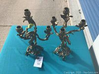 Full view of the two brass candelabras showing their overall size and design.