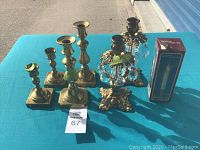 Photo showing all seven assorted candlesticks including brass candlesticks and two ornate crystal prism candle holders, plus an original box for an electric candle lamp.