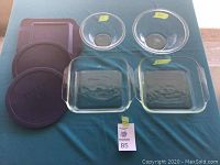 Full lot arranged on a blue cloth surface showing all 7 pieces including bowls and lids.