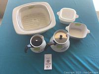 All 8 pieces laid out on table including large casserole dish with lid, smaller casserole dishes of varied sizes, and saucepans with lids