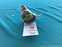 Glass dove paperweight photographed from side on blue cloth surface with measurement label showing 3.5 inches.