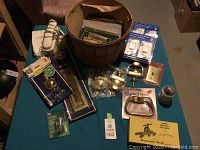Overhead view of assorted hardware items, basket, and vintage phone on teal table