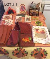 Full lot overview on table showing tablecloth, towels, napkins, oven mitts, and turkey figurines