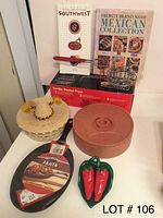 Photo showing two cookbooks, a Corona fajita pan, a tortilla basket fryer, two tortilla storage containers, and chili pepper salt and pepper shakers.