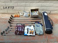 Golf clubs laid out showing driver, irons, putter, golf balls, bags and golf accessories.