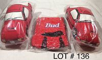 Two Mazda X-7 car pillows and one small red inflatable Budweiser car still in plastic wrapping, shown on white background.