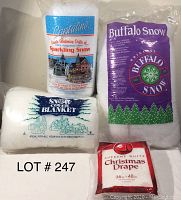Photo showing three bags of Christmas artificial snow (Crystalline Sparkling Snow, Buffalo Snow, Snow Cover Blanket) and one bag of Supreme White Christmas Drape, all labeled and in plastic packaging.