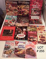 Photo of 11 holiday-themed cookbooks and magazines arranged in rows, shows colorful festive covers with images of Christmas foods and holiday treats.