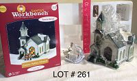 Photo showing retail box of Santa's Workbench Cedar Valley Chapel porcelain house in the Towne Series and the house out of box with electrical cord wrapped beside it
