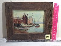 Original oil painting by Peg Gilman with natural rustic wood frame, showing harbor scene with boats and dock buildings, alongside measuring tools to show size.