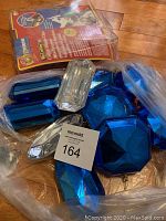 Photo showing assorted large blue and clear faceted plastic Christmas ornaments in a plastic bag with auction tag