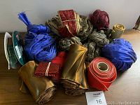 Lot of garlands in blue, gold, red, burgundy colors rolled and bundled on wooden surface