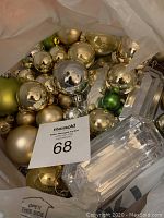 Photo showing assorted gold, green, and silver Christmas ornaments and clear faceted decorative pieces.