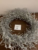 Full view of the sparkly silver Christmas wreath showing circular shape and glittery branches.
