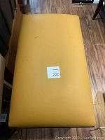 Top view of bench seat showing yellow leather upholstery worn with visible marks and scuffs.