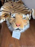 Close-up front view of the tiger rug showing the detailed toy tiger head with facial features and attached limbs