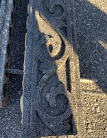 Close-up of two rubber garden edging pieces showing decorative scroll pattern and texture.