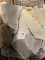 Photo of assorted fabric in beige, cream, and taupe tones, arranged loosely showing texture and color variations.