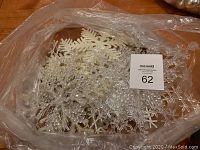 Various snowflake ornaments and decorations in a plastic bag.