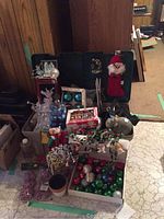 Lot showing assorted Christmas decorations including boxes of glass ornaments, fabric Santa, clear angel figurine, and bead garlands.