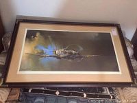 Full view of the framed print leaning against wall on floor