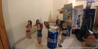 Side view showing five female figurines dressed in varied outfits with a Labatt's Blue beer can for scale.