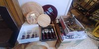 Overview of cheese boards, cheese knife sets, and corkscrews in boxes and loose stacks.