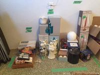 Wide view of the lot showing boxed candle holders, angel statues, coasters, and other candle-related materials.