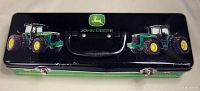 Top view of John Deere tractor tin box showing black handle, two tractor graphics and logo
