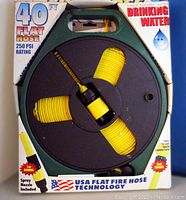 Front packaging showing coiled yellow flat hose on dark green reel with spray nozzle visible. Highlights 40 ft length, 250 PSI rating, and safe for drinking water use.