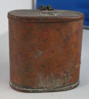 Front and side views showing rusty metal canister with clasp and loop on lid, surface wear and corrosion visible.