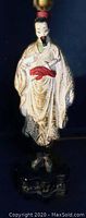 Front view of vintage chalkware Asian male warrior figure lamp without bulb lit, showing detailed robe and facial features.