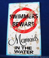 Front view of rectangular metal sign with red prohibition symbol and black/cursive text on white background with blue border showing distressed paint.