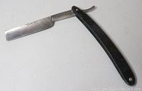 Full view of the vintage S. Pearson & Co. straight razor with black handle and metal blade open, showing blade and handle detail.