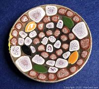 Top view of round ashtray showing multicolored mosaic stone pattern.