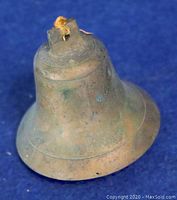 Front side view of the vintage brass bell showing patina and old rope tied at the top.