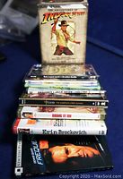 Photo showing top and side view of DVD collection stacked with visible titles and box set of Indiana Jones