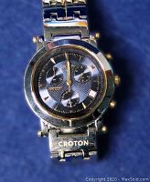 Close-up photo of the watch dial showing chronograph subdials, date window, and branding.