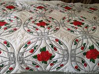 Overview of full quilt showing double wedding ring pattern and rose motifs