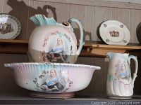 Wide shot of wash basin, large and small pitchers on shelf