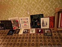 Multiple velvet paintings with nature and animal themes displayed on carpeted floor, various sizes including largest approximately 18x21 inches