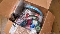 Box with assorted colored thread spools and three blue plastic embroidery hoops visible inside