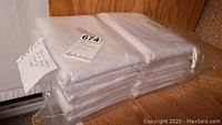 Packaged white quilt blocks stacked and wrapped in plastic, showing quantity and condition.