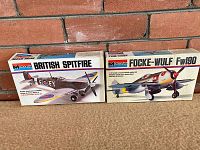 Photo of two Monogram model kits in original open boxes. Left box is British Spitfire, right box is Focke-Wulf Fw 190.