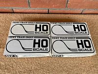 Four unopened gray and black boxes with HO scale logo visible from Tichy Train Group containing vintage model train kits.