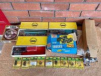 Wide view of vintage model train accessories in original and unopened packaging with multiple box styles and various components included.