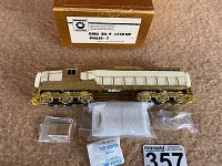 Locomotive shell laid on table with two plastic bags containing parts, silica gel pack and MaxSold tag