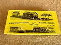 Top of the kit box showing black and white illustrations of four model structures included in the kit and descriptive text about the contents.